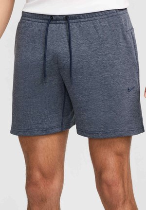 Dunkelgraue sportliche Shorts bis zur Mitte des Oberschenkels mit elastischem Bund, dunkelblauen Kordeln, Seitentaschen und kleinem Nike-Logo am linken Bein.