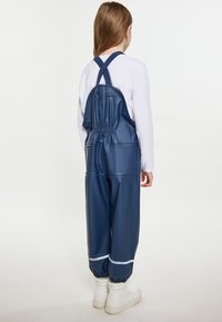 Námornícky modré vodoodpudivé traky s elastickým pásom, nastaviteľnými krížovými popruhmi a bielymi manžetami. Hladká, lesklá textúra.