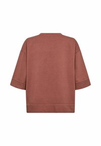 Un top supradimensionat cu mâneci scurte, într-o nuanță muted de terracotă. Material moale din bumbac, cu un design simplu și o gâtă largă.