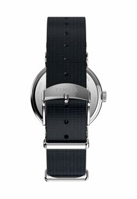 Timex watch with a black textured fabric strap and silver stainless steel buckle, featuring a round stainless steel case.