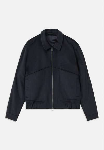 Mørkeblå jakke med krave, frontlynlås og elastiske manchetter. Har to sidelommer og et glat, struktureret design.