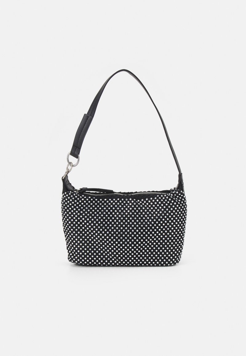 Sac à main noir à pois blancs, une courte bandoulière avec un anneau en argent et une fermeture éclair sur le dessus.