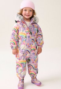 Bunte, gepolsterte Schneejacke in Lavendel mit Regenbogen- und Tiermustern, ausgestattet mit einer gefütterten Kapuze und elastischen Bündchen. Kombiniert mit lila Stiefeln.