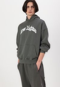 Sweatshirt cinza com capuz e bolso frontal, apresentando "low lights" em texto bordado branco no peito e punhos canelados.