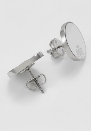 Paire de boucles d'oreilles clous rondes en argent avec fermoirs papillon et logo gravé discret sur la surface avant.