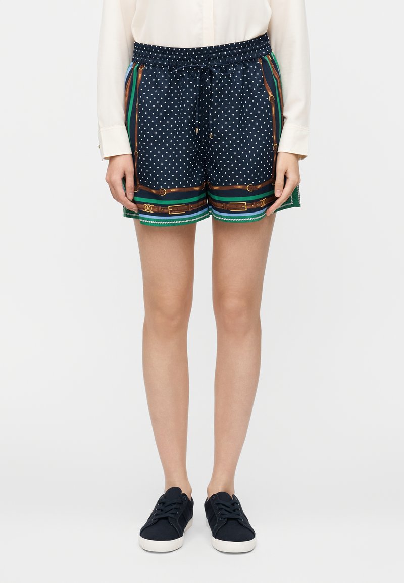 Calções de bolinhas azul-marinho com cintura elástica e cordão; apresentam padrão listrado colorido na bainha e detalhes em metal dourado.