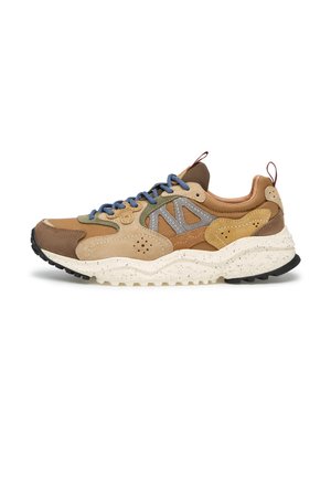 Sneaker robusta con pannelli misti in suede marrone e beige e pelle, lacci blu, suola bianca maculata e battistrada nero, vista laterale su sfondo bianco.