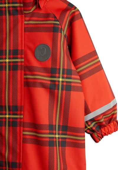 Chaqueta de lluvia a cuadros rojos, fabricada con material duradero, que presenta franjas negras y amarillas, puños elásticos y un parche de logo redondo.