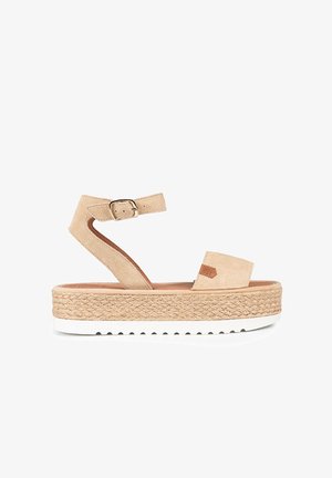 Sandalias de plataforma beige con parte superior de ante, correa de tobillo con hebilla y suela media tipo yute trenzado. Suela exterior de goma blanca con agarre texturizado.
