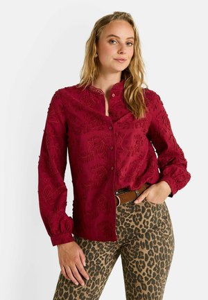 Chemise bordeaux brodée avec fermeture à boutons, dotée d'un col mandarin et de longues manches bouffantes, associée à un pantalon à imprimé léopard.