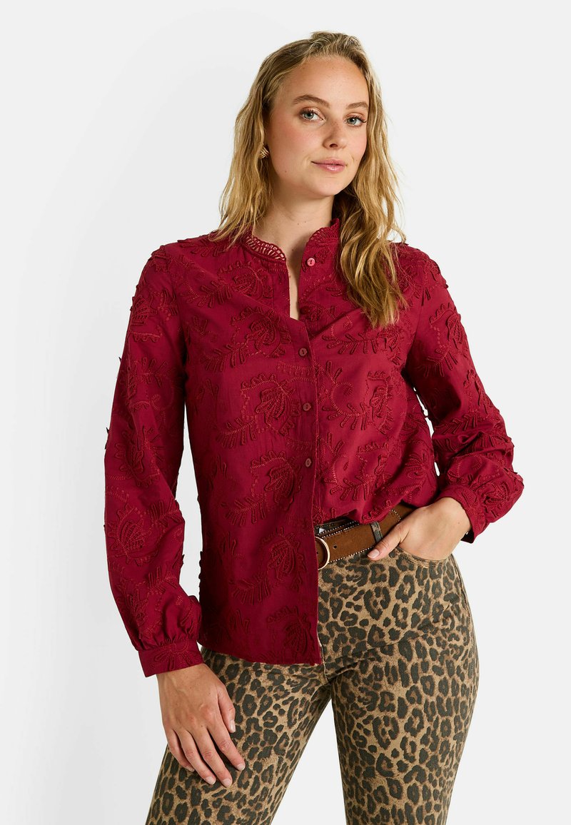 Chemise bordeaux brodée avec fermeture à boutons, dotée d'un col mandarin et de longues manches bouffantes, associée à un pantalon à imprimé léopard.