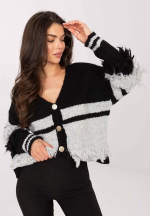 Black and gray knitted cardigan with V-neck, three large decorative buttons, and fringe detailing on sleeves and hem. Striped pattern.