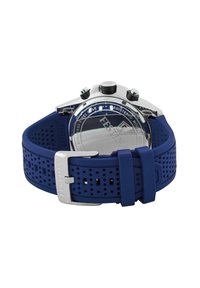 Montre avec bracelet en caoutchouc bleu et boîtier en acier inoxydable. Elle présente un fond métallique lisse et trois boutons texturés noirs sur le côté droit.