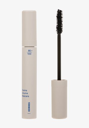 Tubo di mascara beige Korres Drama Volume con l'applicatore a spazzola rimosso e in piedi accanto al tubo.