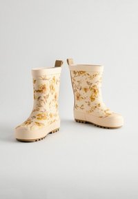 Bottes en caoutchouc crème à motif floral, avec une semelle texturée et un bord renforcé. Comprend des languettes pour un enfilage facile.