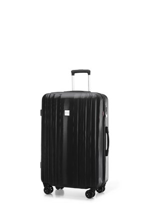 Black hard-shell suitcase with vertical ridges, retractable handle, and four spinner wheels. Features a small logo and side handle.