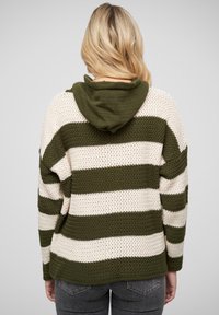 Hanorac rayé cu un schema de culori verde măslin și crem. Prezintă un tricot texturat, o glugă mare și o croială relaxată.