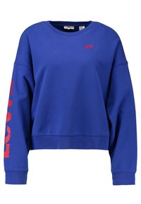 Niebieski skrócony polarowy sweter wykonany z bawełny, z okrągłym dekoltem i opadającymi ramionami. Na lewym rękawie sportowy czerwony napis "LEVIS".