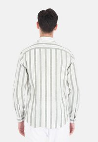 Camicia da uomo a maniche lunghe con strisce verticali grigie e bianche, polsini con bottoni e colletto standard, realizzata in tessuto leggero e testurizzato.