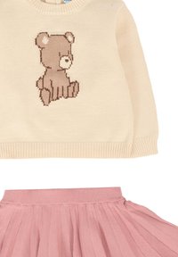 Maglione lavorato a maglia crema con motivo di un orso bruno, abbinato a una gonna in tulle rosa con vita arricciata per un look a più strati.