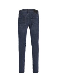 Jeans de mezclilla azul oscuro con un diseño ajustado, que cuentan con bolsillos traseros y una etiqueta en la cinturilla texturizada. Acabados de costura mínimos.
