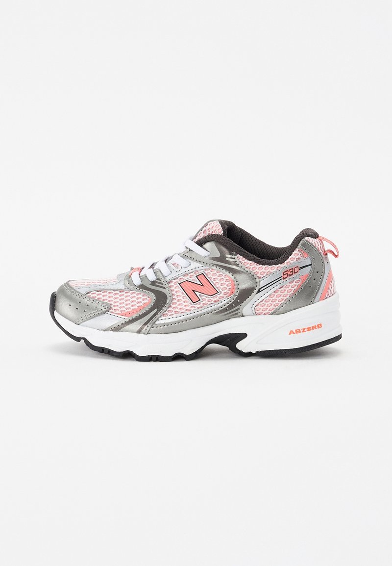 Chaussure de sport New Balance blanche, rose et grise avec détails en mesh, design à lacets et logo brandé "N" sur le côté.