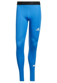 Niebieskie legginsy sportowe z gładkiego, elastycznego materiału. Posiadają czarną talię i białe logo Adidas na lewym dolnym udzie.