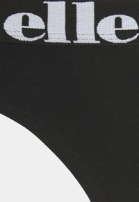 Black cotton underwear with a wide elastic waistband featuring white lettering. The fabric is smooth with a slight sheen, narrowing at the sides.