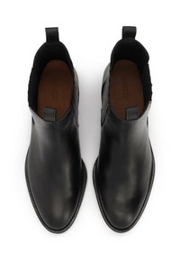 Stivali alla caviglia in pelle nera con una finitura liscia, cuciture decorative e linguette laterali per facilitarne l'indossamento.