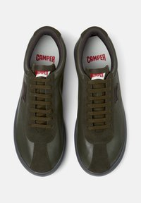 Olive green leather sneakers with round toes, flat laces, and rubber soles. Features red "CAMPER" branding on insoles and side accents.