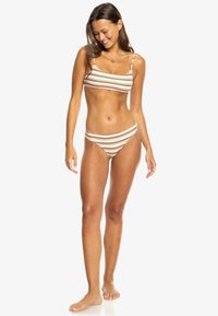 Striped bikini set in pastel colors featuring thin straps and a low-rise bottom. The fabric appears smooth with a soft texture.