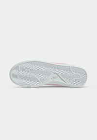 Λευκή σόλα παπουτσιού Nike με μοτίβο ψαροκόκκαλο και λογότυπο Nike στο κέντρο, απεικονίζεται σε απλό λευκό φόντο.