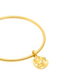 Złota bransoletka typu bangle z teksturowanym charms z dyskiem, ozdobionym niebiańskimi grawerunkami oraz małymi przezroczystymi kamieniami jako akcent.