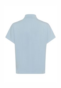 Light blue short-sleeve polo shirt with a straight hem, soft texture, and a small collar. Back view displays minimal stitching and no embellishments.