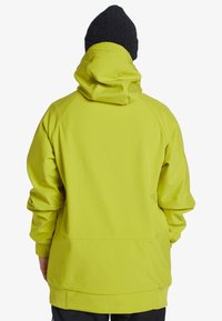 Ljusgul huva jacka med avslappnad passform, raglanärmar och en slät yta. Har en tät krage och elastiska ärmslut.