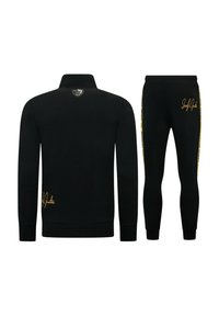 Zwarte trainingsset bestaande uit een ritssluiting bovenstuk met hoge kraag en een logo met gouden accenten, gecombineerd met tapered broek met zijstreepdetails.