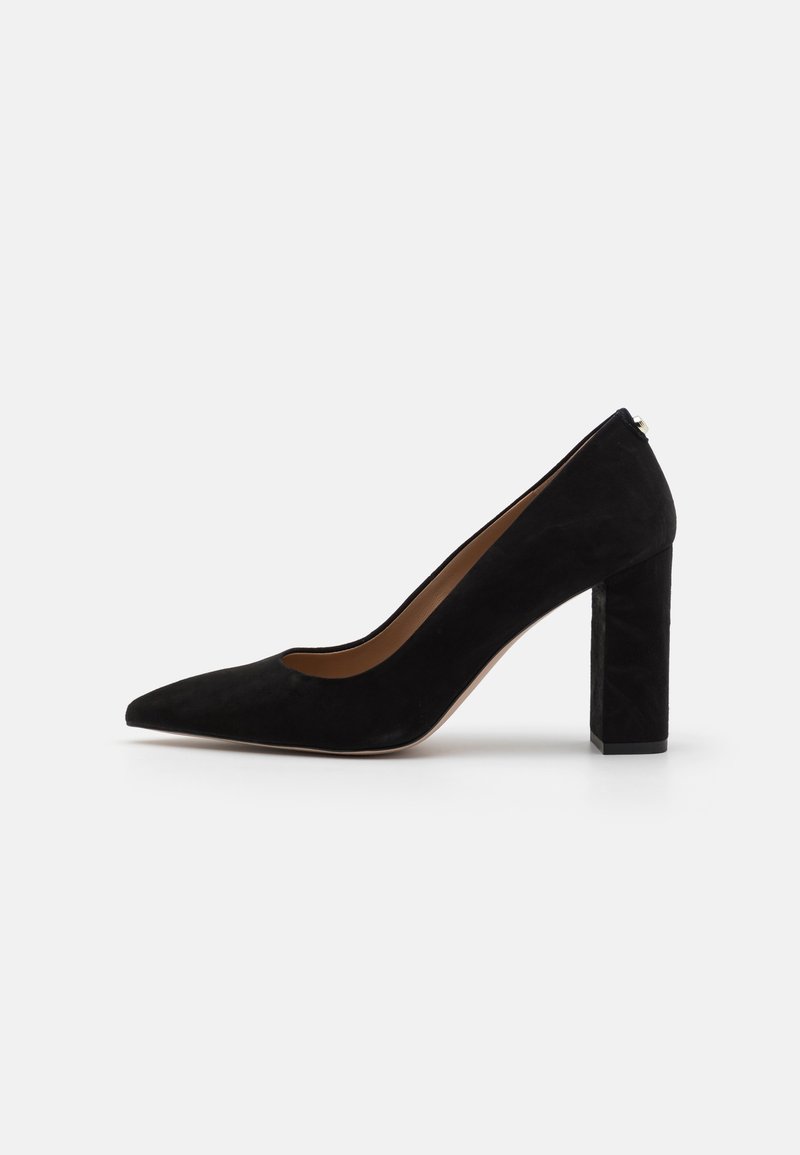 Escarpin à talon haut en daim noir avec bout pointu et talon épais bloc, vu de côté sur un fond clair.