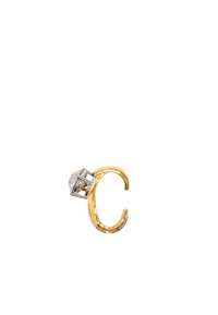 Anillo de metal dorado con una piedra clara engastada en una jaula geométrica de metal plateado. Diseño abierto con textura suave y acabado pulido.