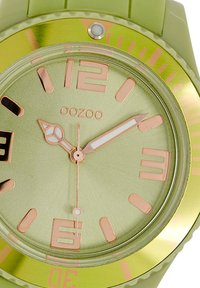 Green silicone watch featuring a matte green dial, rose gold accents, bold hour markers, and a contrasting gold bezel.