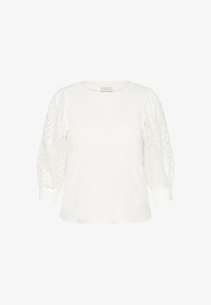 Bela majica s kratkimi, napihnjenimi rokavi iz čipke. Okrogla izrez in enobarven del, z teksturiranimi vzorci čipke na rokavih.