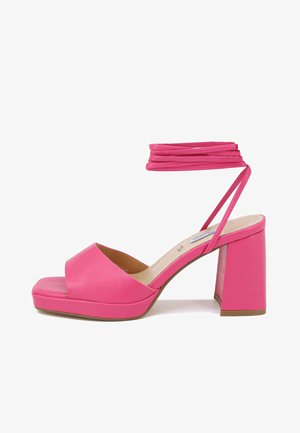 Sandalo con tacco rosa, dotato di una cintura larga sulla punta, punta quadrata e cinturino alla caviglia. Presenta un tacco spesso e materiale sintetico liscio.