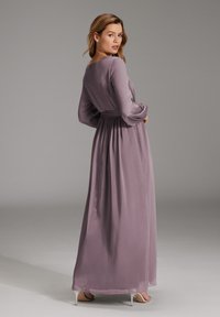 Langes, fließendes mauvefarbenes Kleid aus leichtem Stoff, mit langen Ärmeln, einer taillierten Taille und einer sanft drapierten Silhouette.