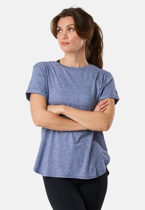 T-shirt blu scagliato a maniche corte con vestibilità rilassata, colletto rotondo e maniche arrotolate. Indossato con leggings neri, che mostrano una texture liscia.