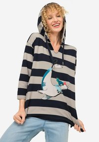 Felpa a righe in tessuto blu navy e beige. Presenta una grafica di un animale con un cappello. Vestibilità ampia, maniche a lunghezza media e design a scollo a V.