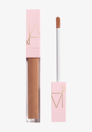 Gloss à lèvres nude-brun brillant et nacré avec un capuchon rose et un logo géométrique doré ; applicateur à côté du tube.