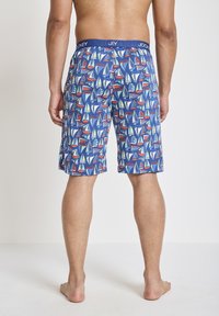 Pantaloni da bagno blu con un motivo di barche a vela in rosso, verde e bianco. Vita elastica con il marchio "Jockey". Tessuto leggero.