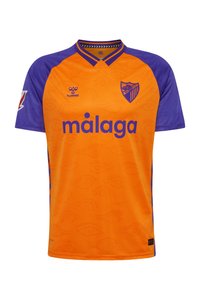 Orange och lila fotbollströja med V-hals, korta ärmar, logotyp och mönstrad textur med ögonmotiv. "Malaga" är tydligt utskrivet.
