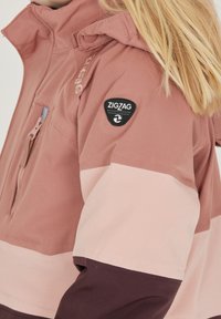 Lätt, rosa och burgundy-färgad jacka med färgblockering, dragkedjeficka, logotyp-patch och hög krage. Har en mjuk tygtextur.