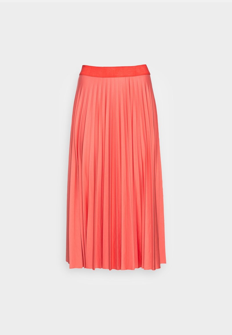 Jupe midi plissée couleur corail rose avec taille ajustée, tombant droit sur un fond gris clair uni.