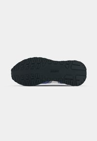 Black rubber outsole with textured grip patterns, featuring a blue and white midsole design. Reinforced edges for durability.